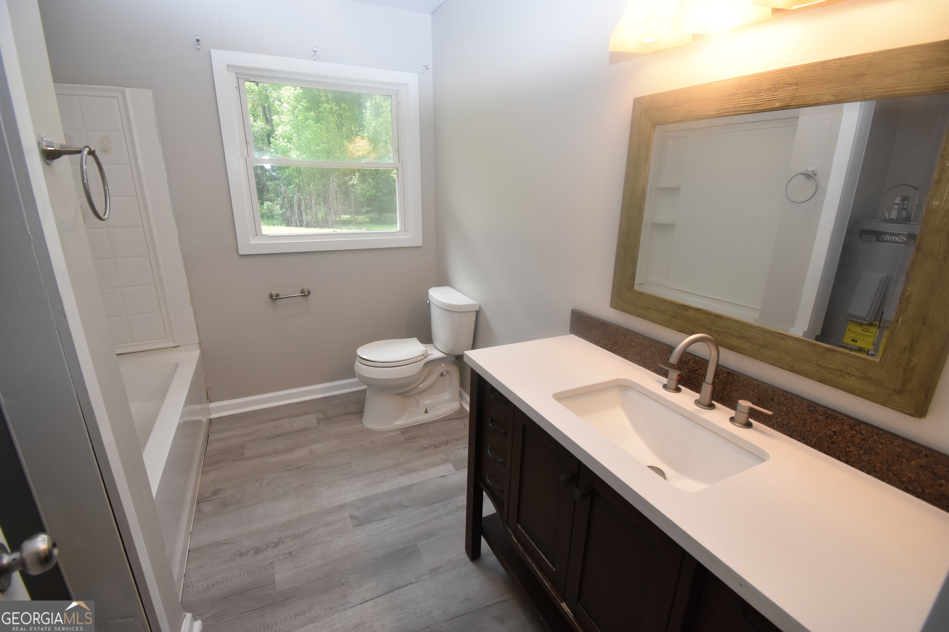 2353 Greenville Road Kingsland, GA 31548 - Photo 12 of 21 a bathroom with a sink a toilet a mirror and a window