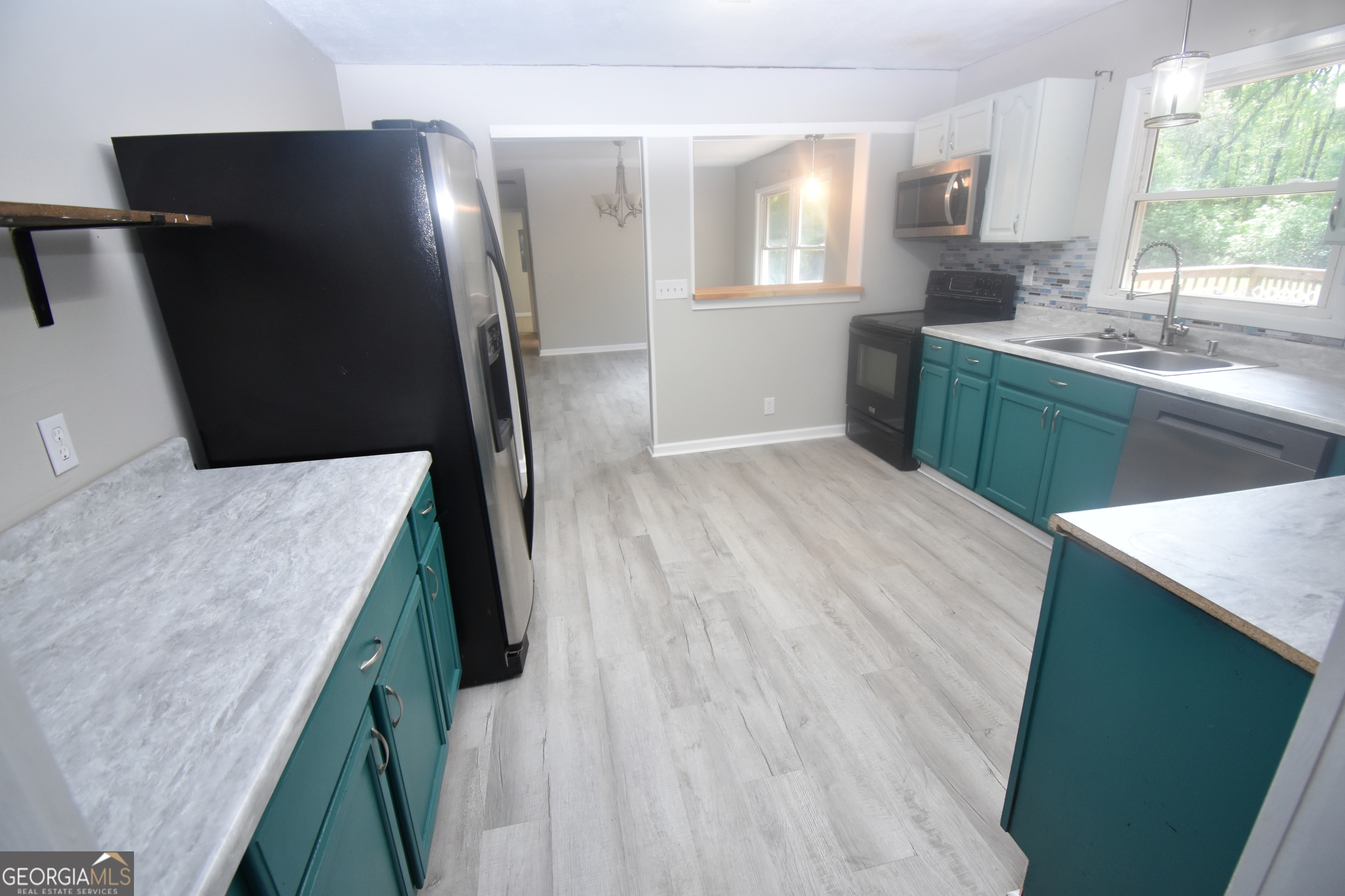2353 Greenville Road Kingsland, GA 31548 - Photo 3 of 21 a kitchen with stainless steel appliances granite countertop a refrigerator a sink a stove and island