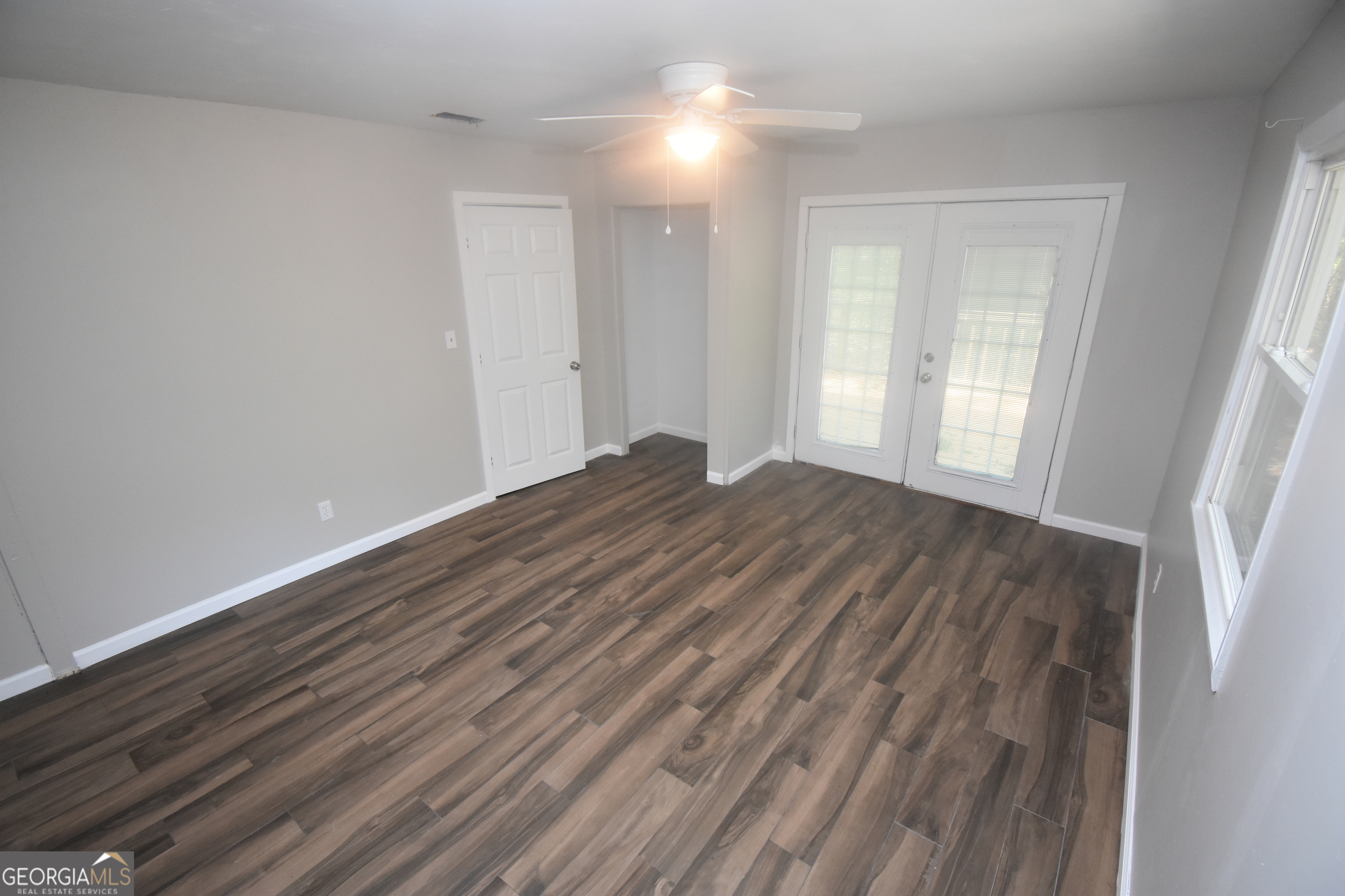 2353 Greenville Road Kingsland, GA 31548 - Photo 4 of 21 a view of an empty room with wooden floor and a window