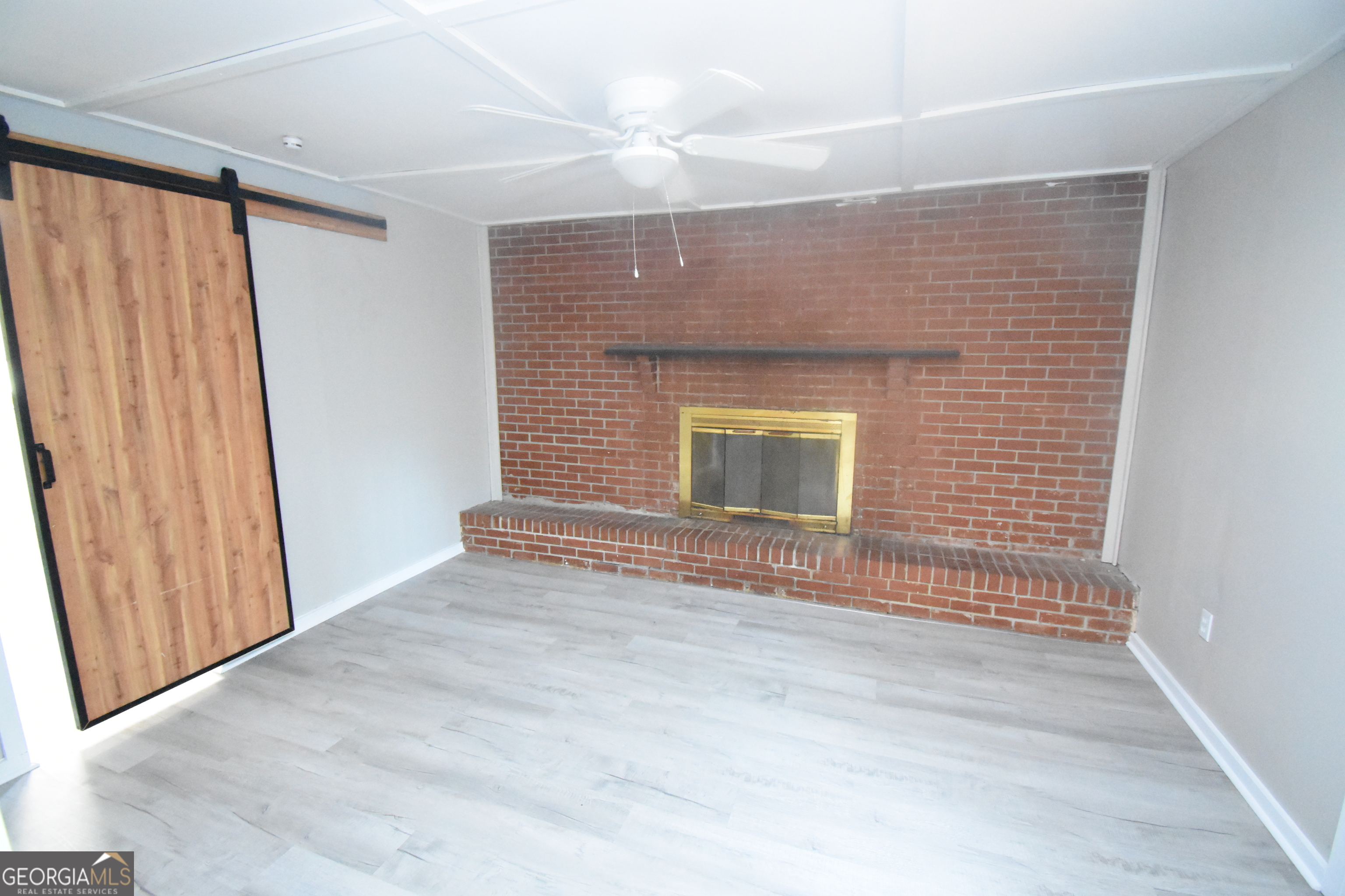 2353 Greenville Road Kingsland, GA 31548 - Photo 6 of 21 a view of empty room with wooden floor and fan