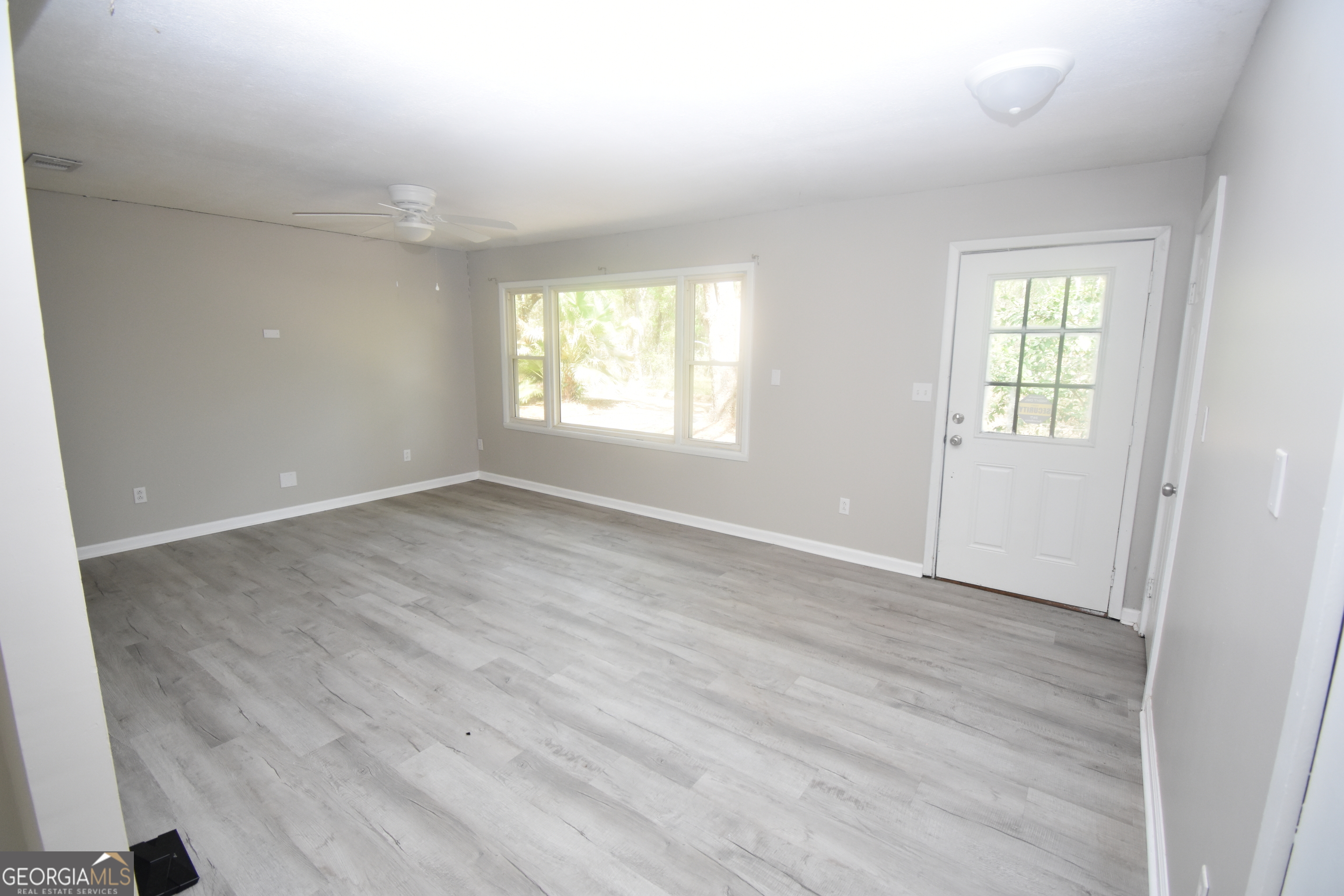 2353 Greenville Road Kingsland, GA 31548 - Photo 8 of 21 an empty room with wooden floor and windows