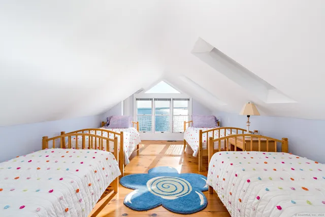 a view of a balcony with wooden chairs and floor to ceiling window