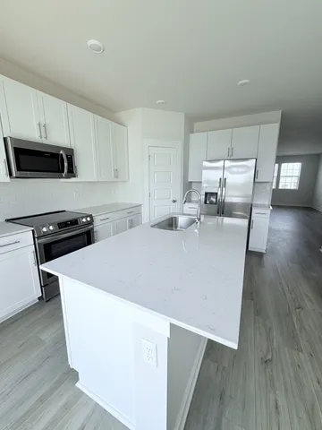 a kitchen with stainless steel appliances a white refrigerator a stove a microwave and cabinets