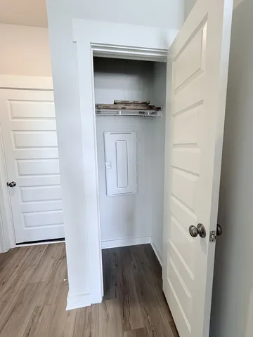 a view of a hallway with wooden floor and staircase