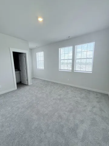 an empty room with a fireplace and windows