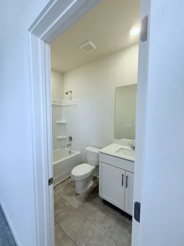 a bathroom with a granite countertop toilet a sink and a mirror