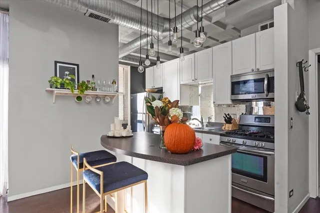 a kitchen with stainless steel appliances kitchen island granite countertop a stove and cabinets