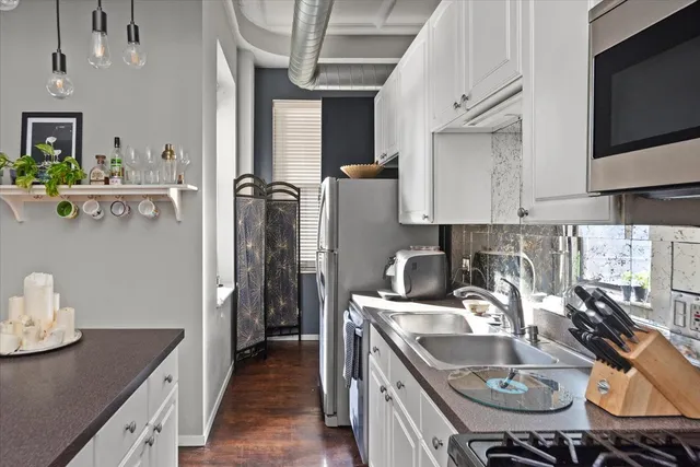 a kitchen with stainless steel appliances granite countertop a sink a stove and a refrigerator