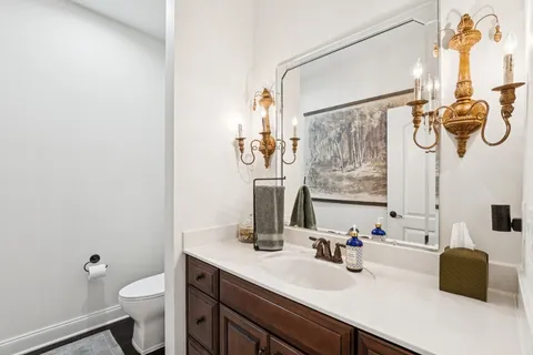 a bathroom with a sink vanity mirror and toilet