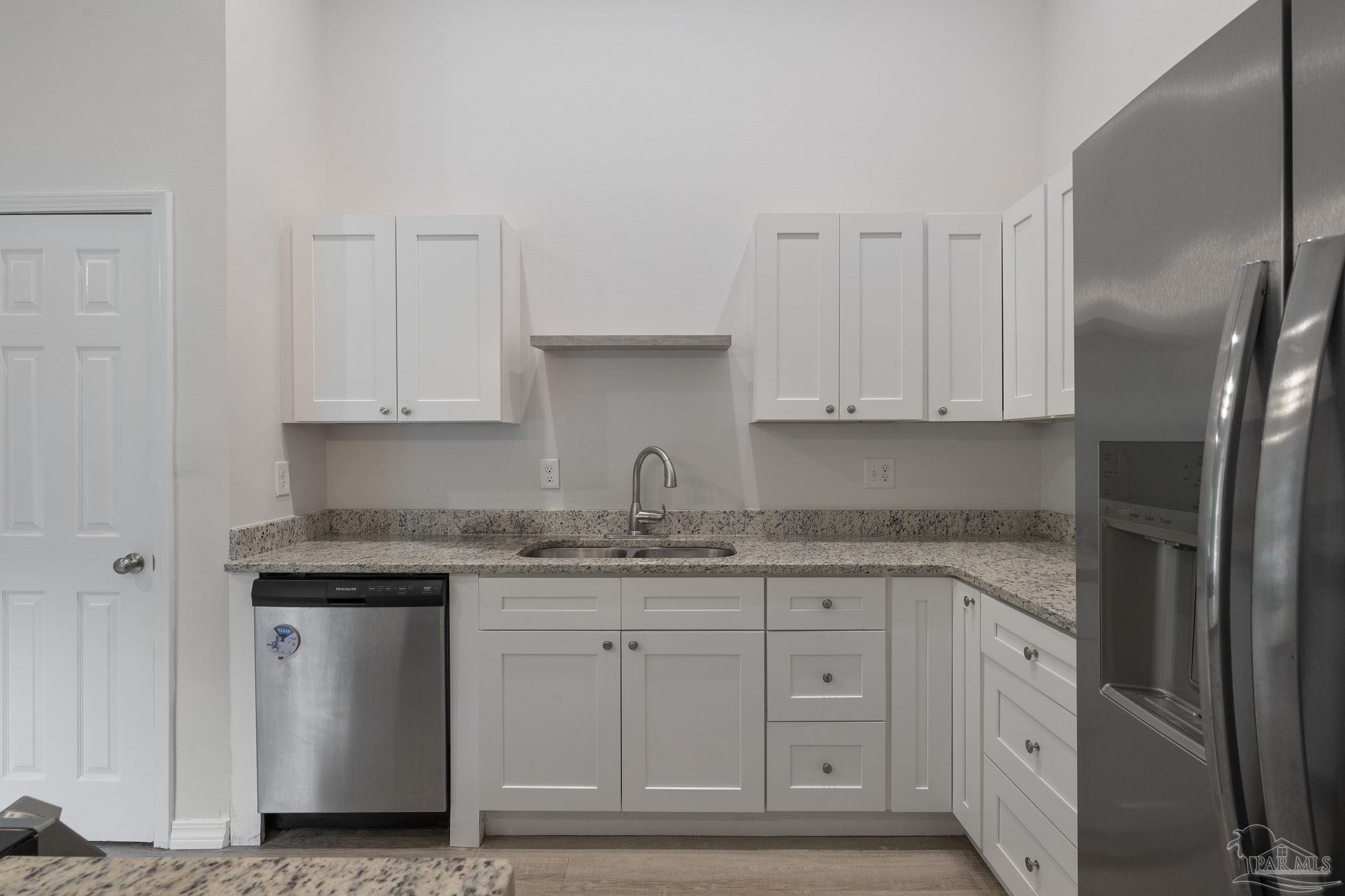 1039 Isabella Road Cantonment, FL 32533 - Photo 12 of 37 a kitchen with stainless steel appliances granite countertop white cabinets and a granite counter tops
