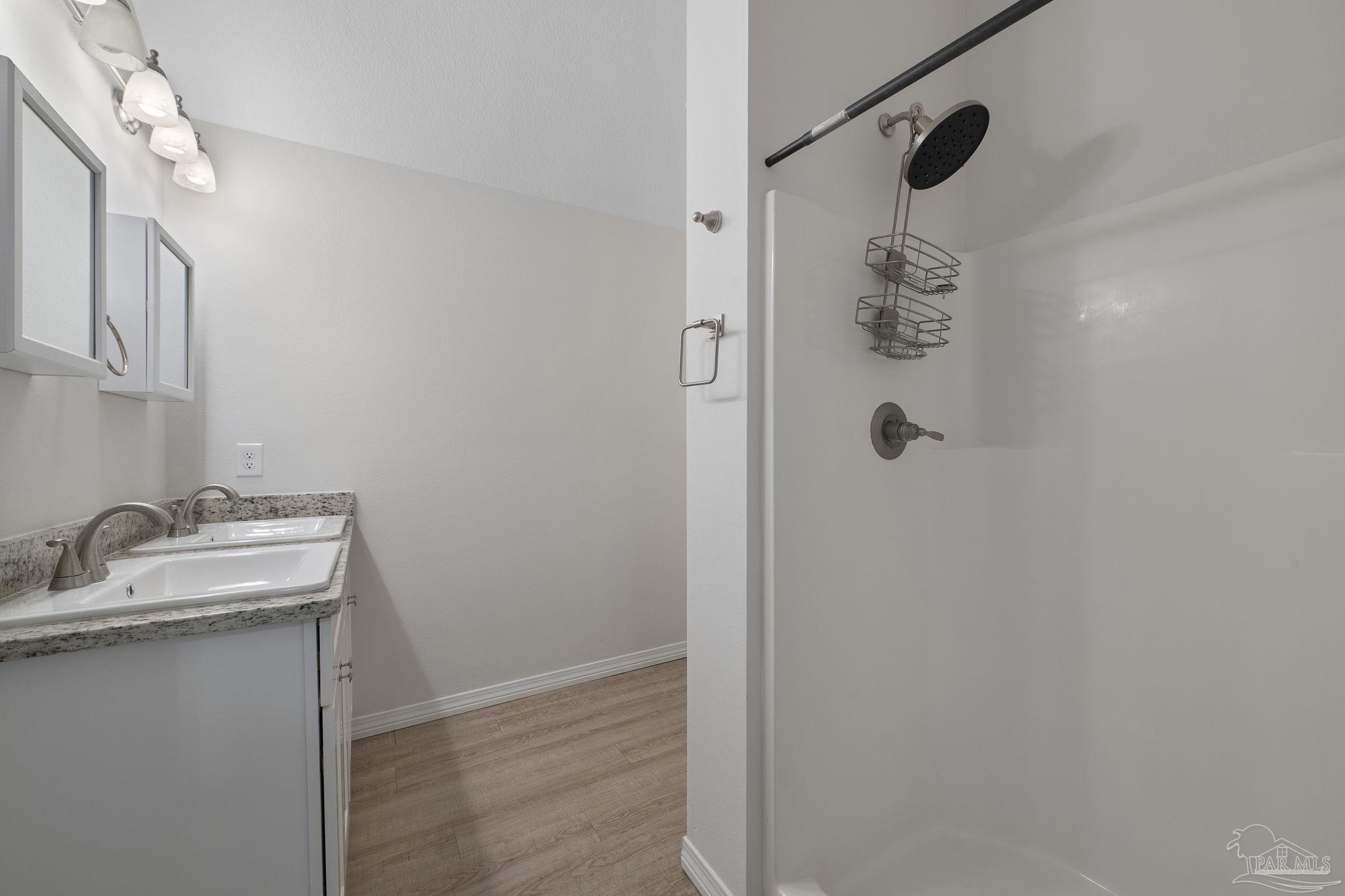 1039 Isabella Road Cantonment, FL 32533 - Photo 18 of 37 a bathroom with a granite countertop shower sink and mirror