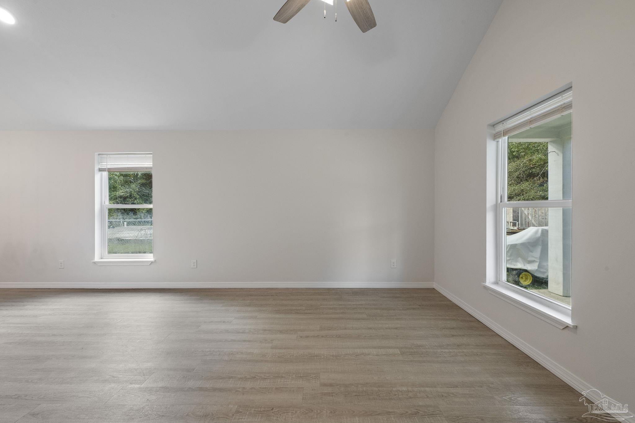 1039 Isabella Road Cantonment, FL 32533 - Photo 5 of 37 an empty room with wooden floor and windows