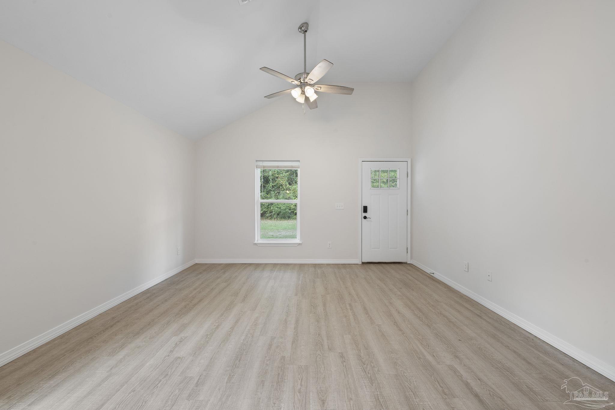 1039 Isabella Road Cantonment, FL 32533 - Photo 6 of 37 wooden floor in an empty room with a window