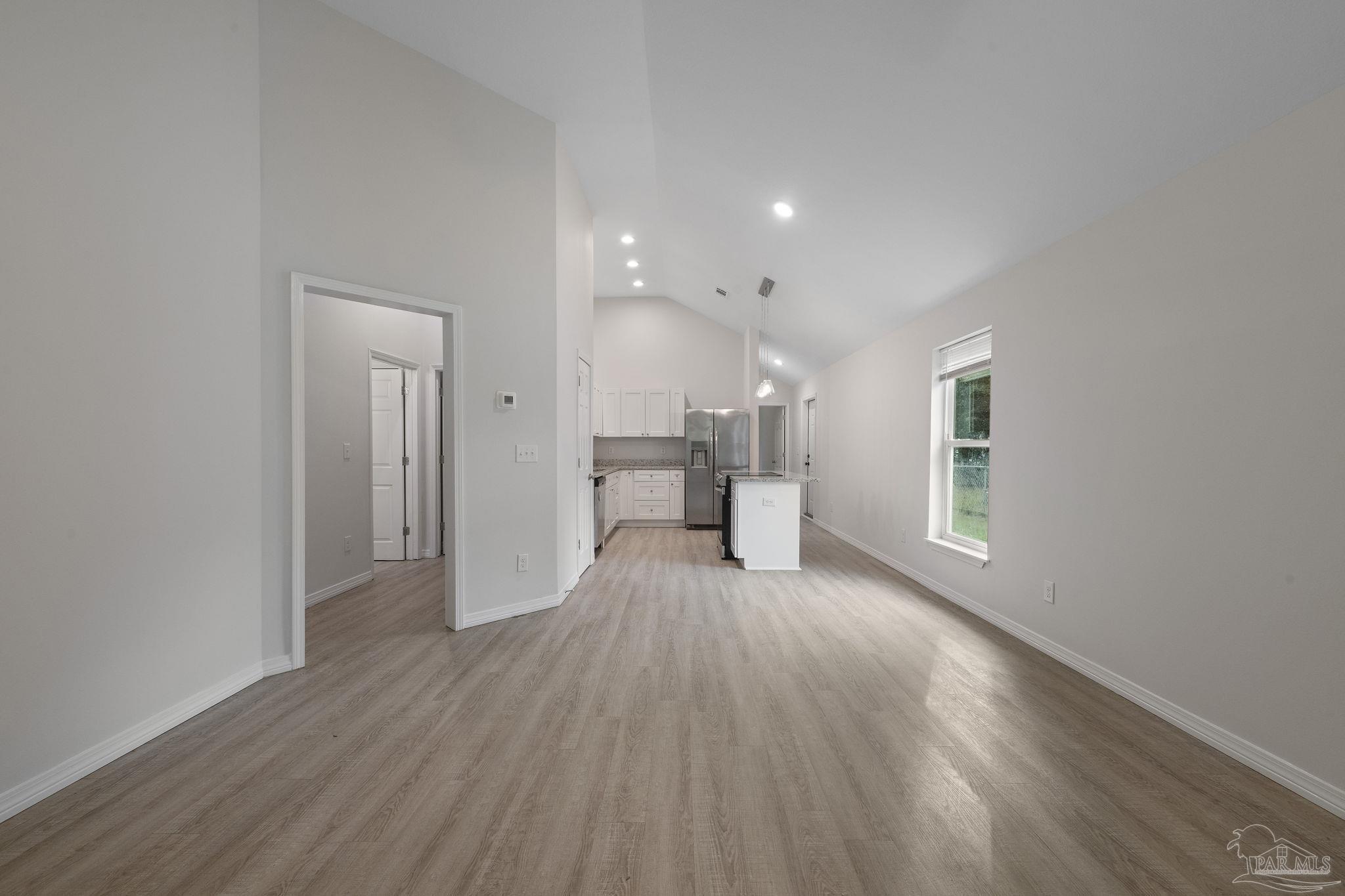 1039 Isabella Road Cantonment, FL 32533 - Photo 7 of 37 a view of an empty room with a window and wooden floor