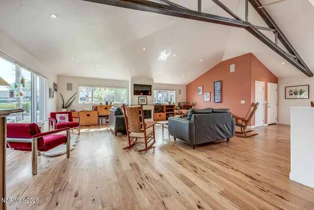a living room with furniture fireplace and a large window