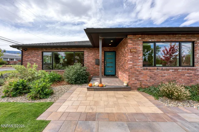 a backyard of a house with barbeque oven table and chairs