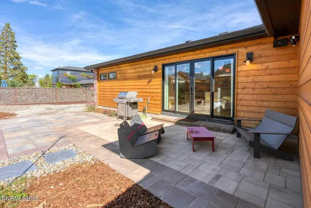 a backyard of a house with barbeque oven and wooden fence