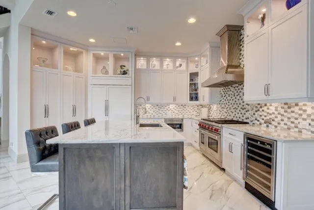 a large kitchen with stainless steel appliances kitchen island granite countertop a stove and a sink