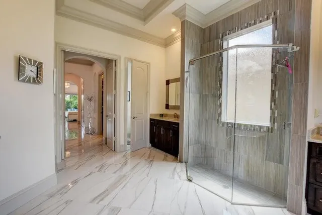a view of a hallway with wooden floor and a bathroom