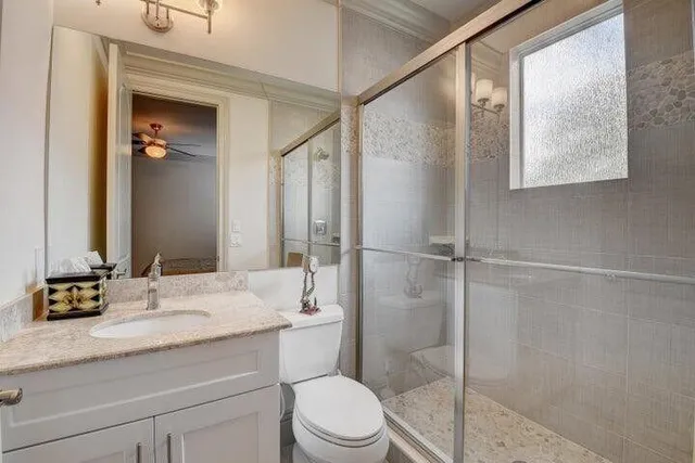 a bathroom with a granite countertop sink toilet and shower