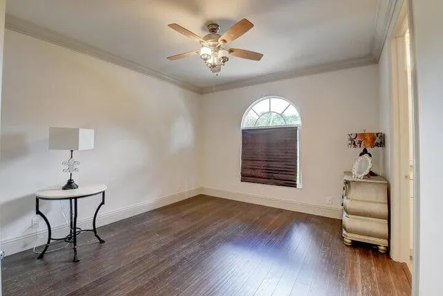 a very nice looking room with wooden floor a chandelier fan and windows