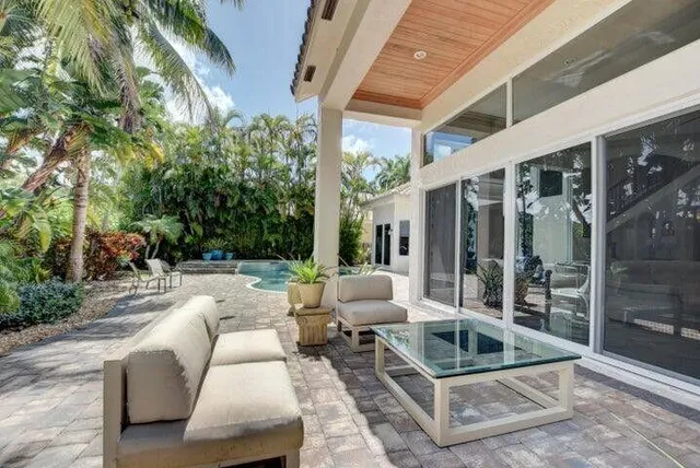 a view of a patio with couches table and chairs and potted plants
