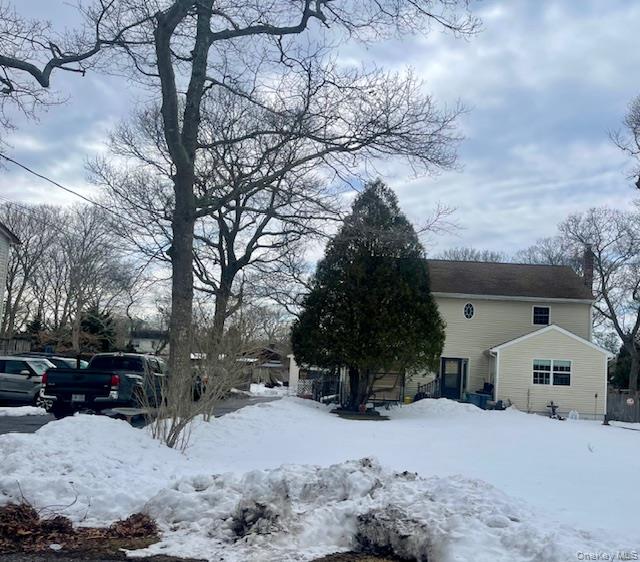 a front view of a house with a yard covered in snow