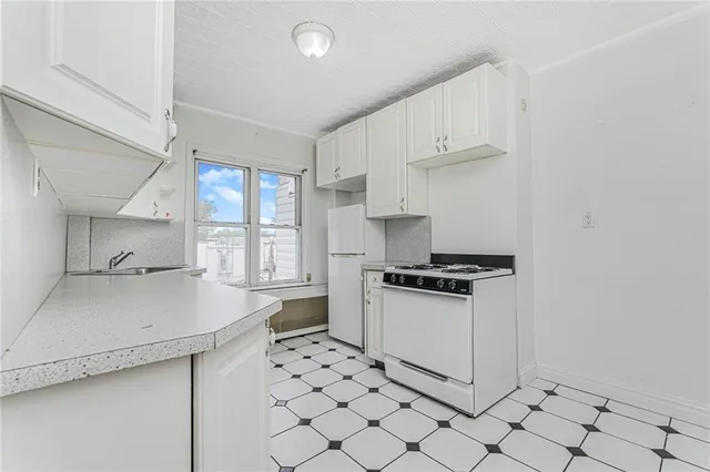 a kitchen with white cabinets and appliances