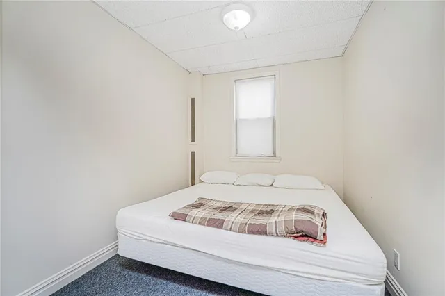 a white bed sitting in a bedroom next to a window