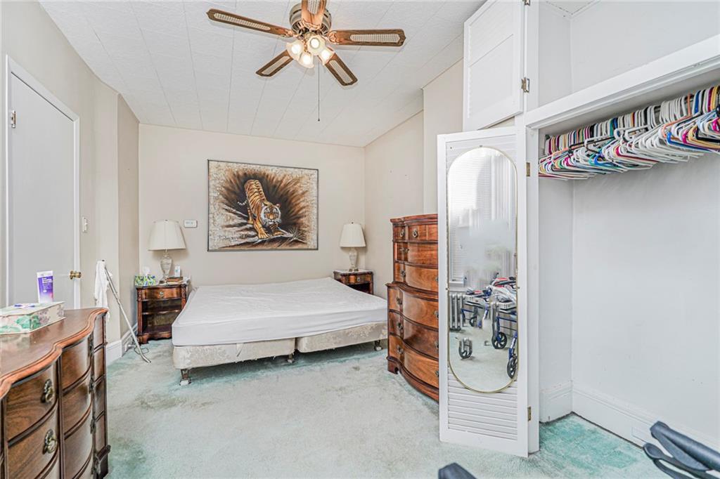 329 80th Street Brooklyn, NY 11209 - Photo 26 of 34 a bedroom with a bed and a chandelier