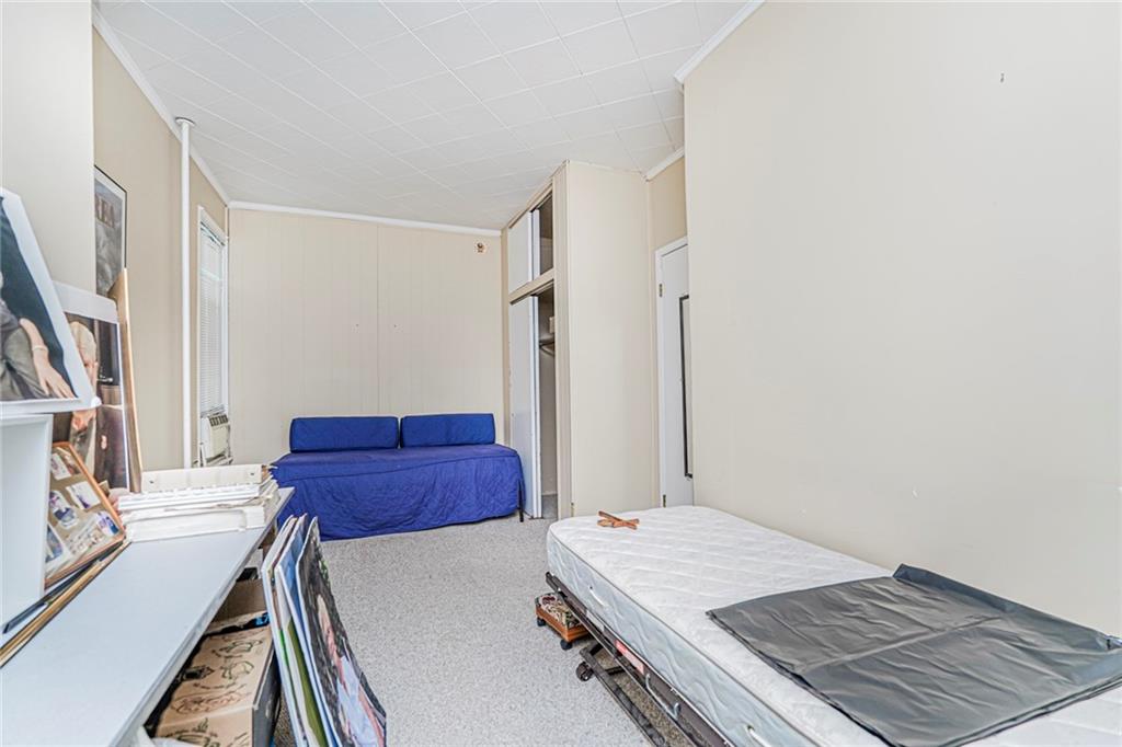 329 80th Street Brooklyn, NY 11209 - Photo 29 of 34 a room with a bed and a dresser