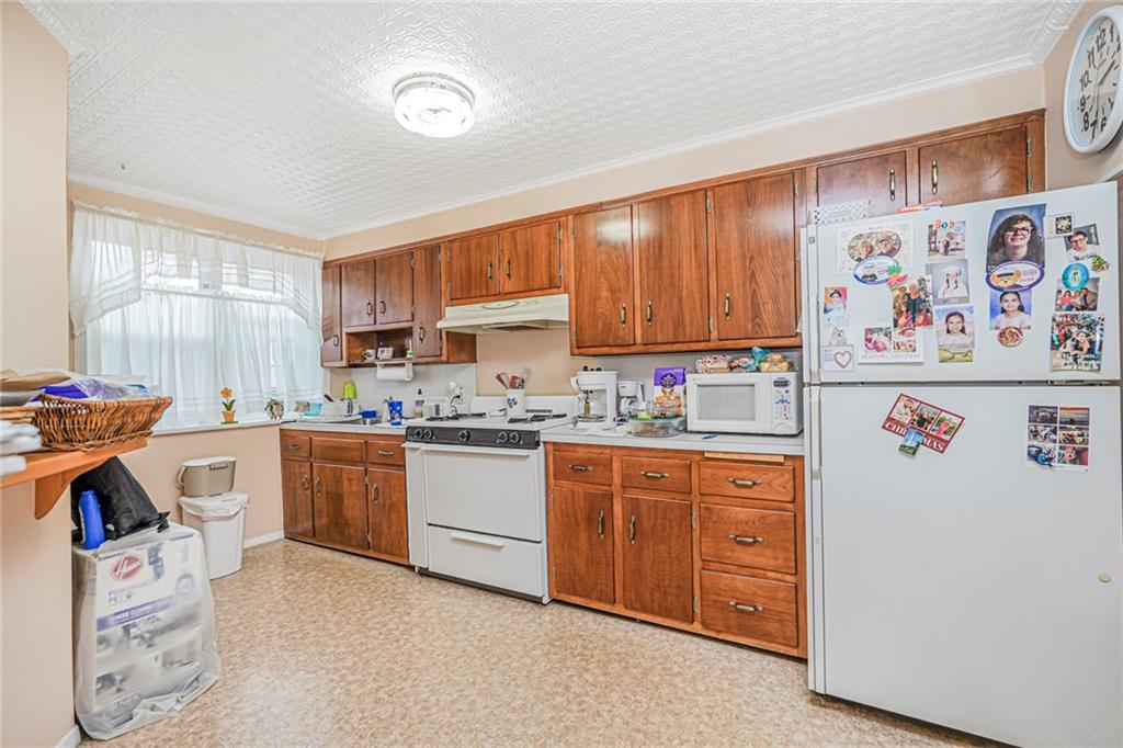 329 80th Street Brooklyn, NY 11209 - Photo 6 of 34 a kitchen with granite countertop a refrigerator and a stove top oven