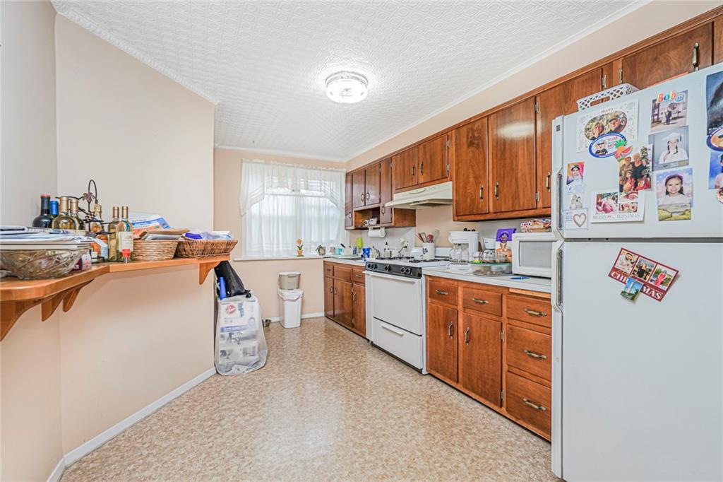 329 80th Street Brooklyn, NY 11209 - Photo 7 of 34 a open kitchen with stainless steel appliances granite countertop a stove top oven a sink a refrigerator and cabinets