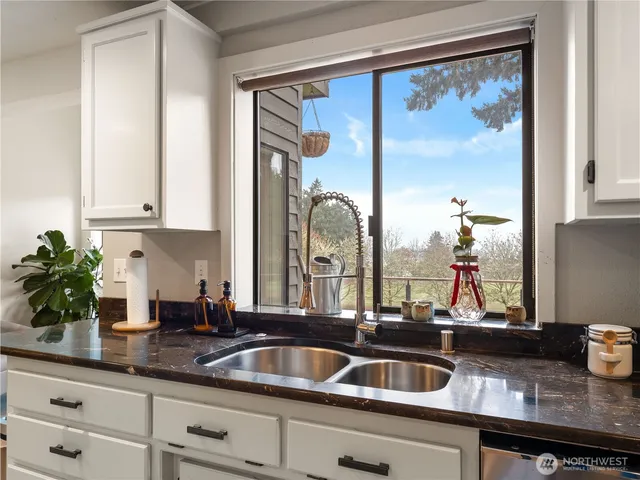 a kitchen with stainless steel appliances granite countertop a sink and cabinets