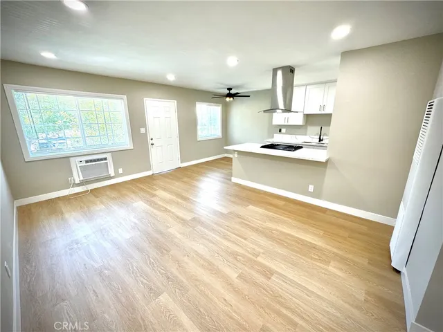 a large kitchen with kitchen island a sink wooden floor and a counter top space