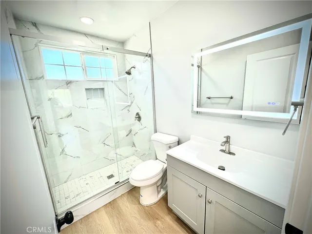 a bathroom with a sink a toilet and shower