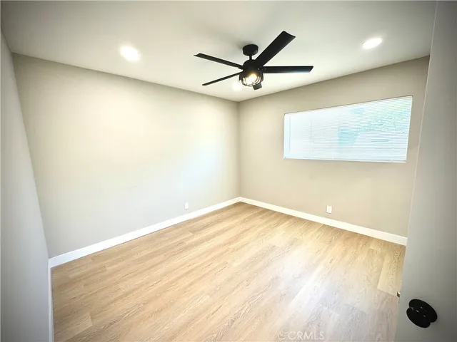 an empty room with a window and a fan