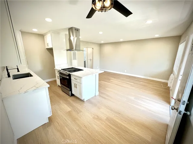 a kitchen with stainless steel appliances granite countertop a sink a stove and a refrigerator