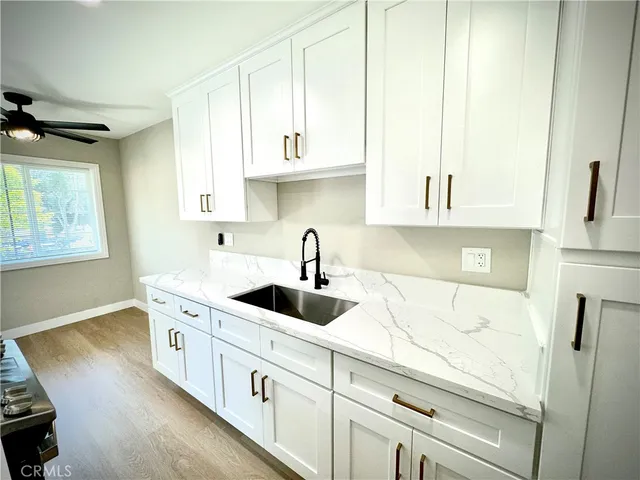 a kitchen with stainless steel appliances granite countertop a sink and a white cabinets