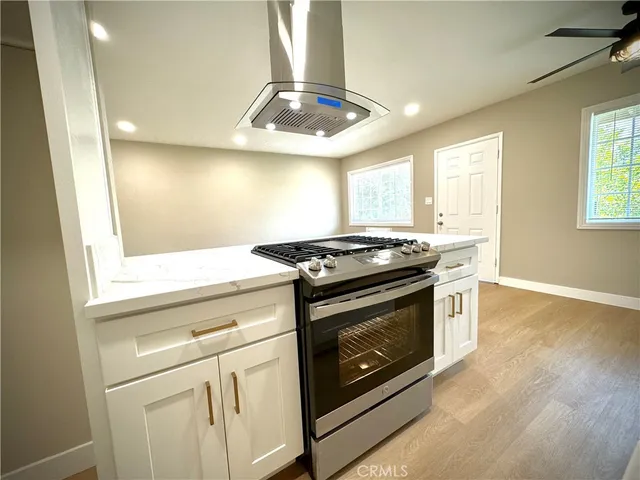 a kitchen with stainless steel appliances granite countertop a stove a sink and a microwave