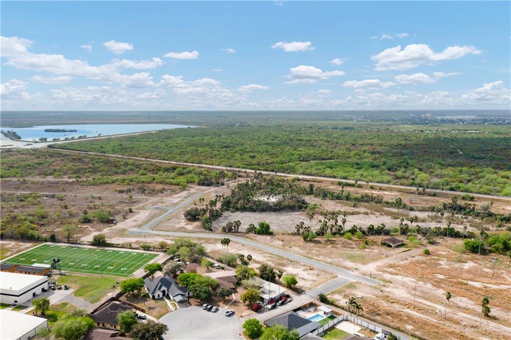 714 Rodeo Drive Hidalgo, TX 78557 - Photo 1 of 6 Expansive land parcel with surrounding vegetation, a distant body of water, and nearby residential structures