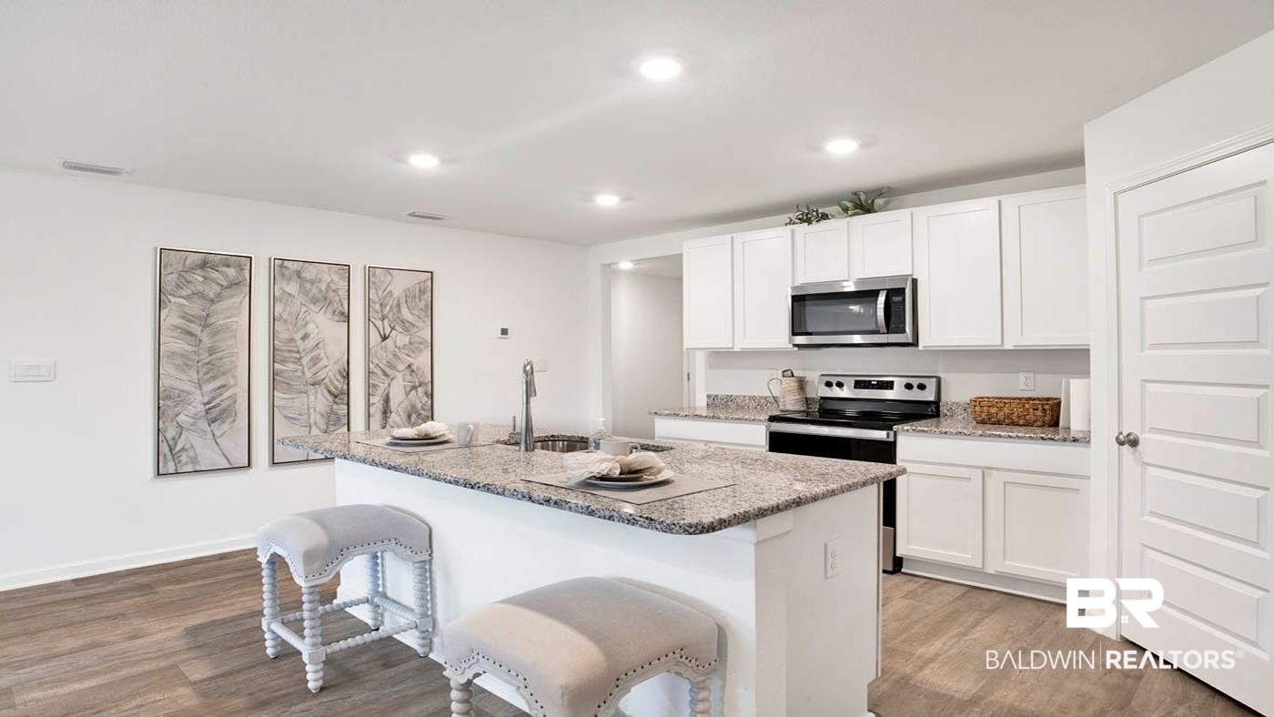24718 Ponder Loop Loxley, AL 36551 - Photo 24 of 31 Kitchen with white cabinetry, stainless steel appliances, an island with sink, and light hardwood / wood-style flooring