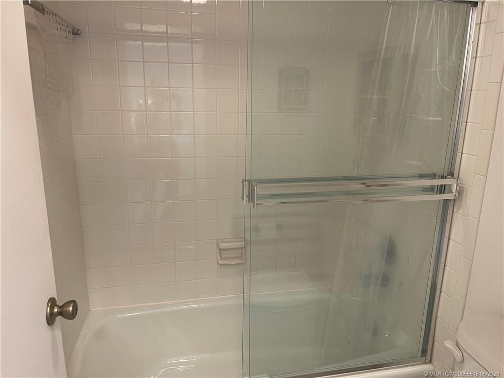 1858 Southwest Palm City Road, Unit 203 Stuart, FL 34994 - Photo 17 of 21 a bathroom with a glass shower door
