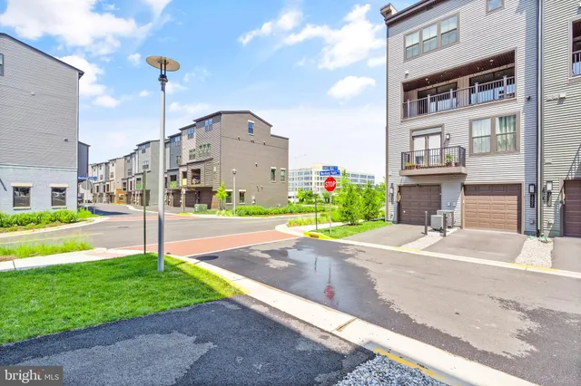 a front view of a building with garden and trees