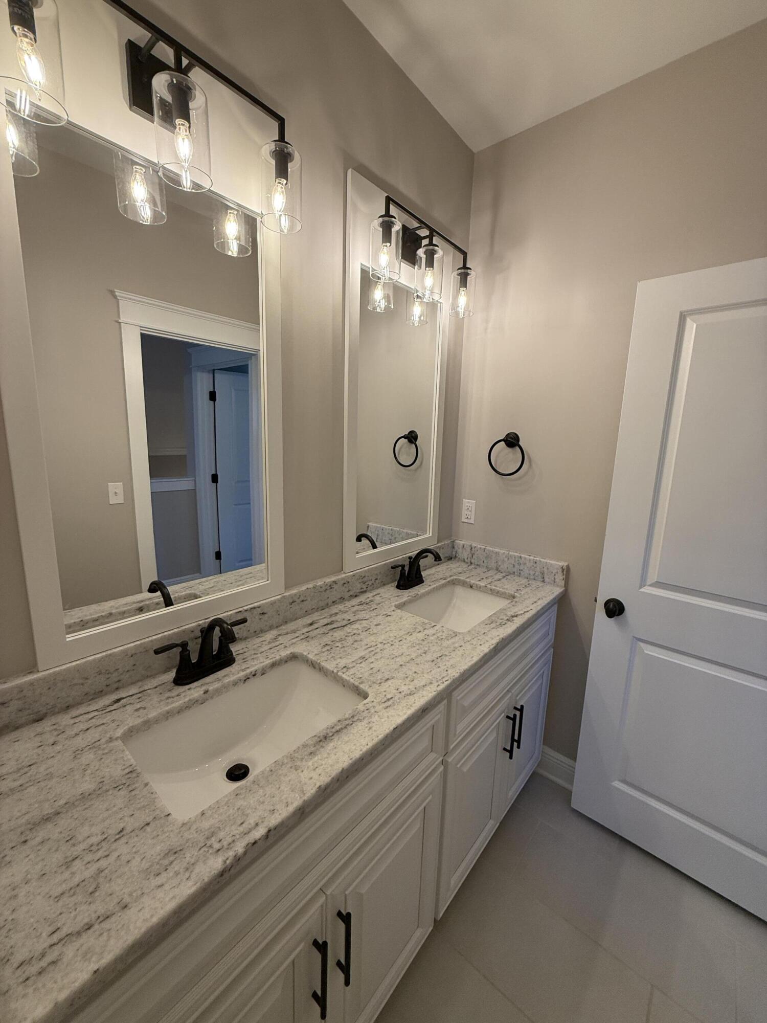79 Mill Pond Cove Freeport, FL 32439 - Photo 36 of 63 a bathroom with a granite countertop sink a mirror and a shower
