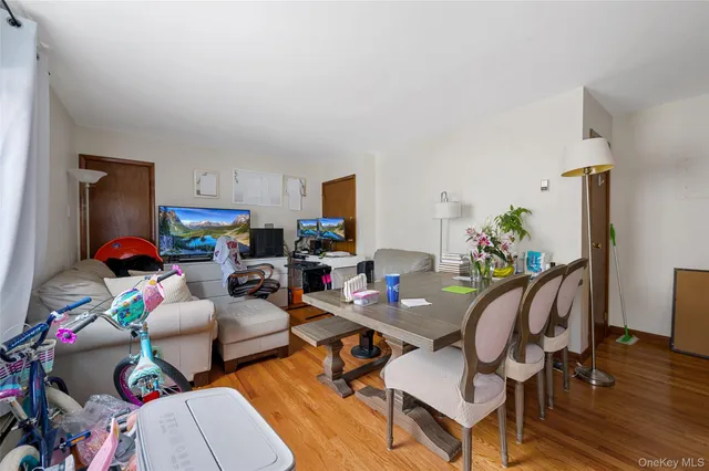 a living room with furniture and a dining table with wooden floor