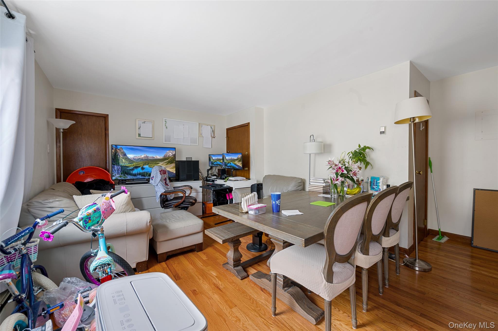 206-16 45th Road Queens, NY 11361 - Photo 5 of 12 a living room with furniture and a dining table with wooden floor