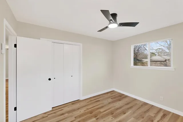 a view of empty room with wooden floor