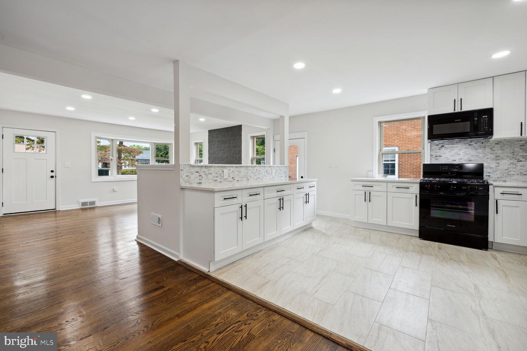 606 Biggs Avenue Frederick, MD 21702 - Photo 4 of 20 a large white kitchen with stainless steel appliances granite countertop a stove and a wooden floors