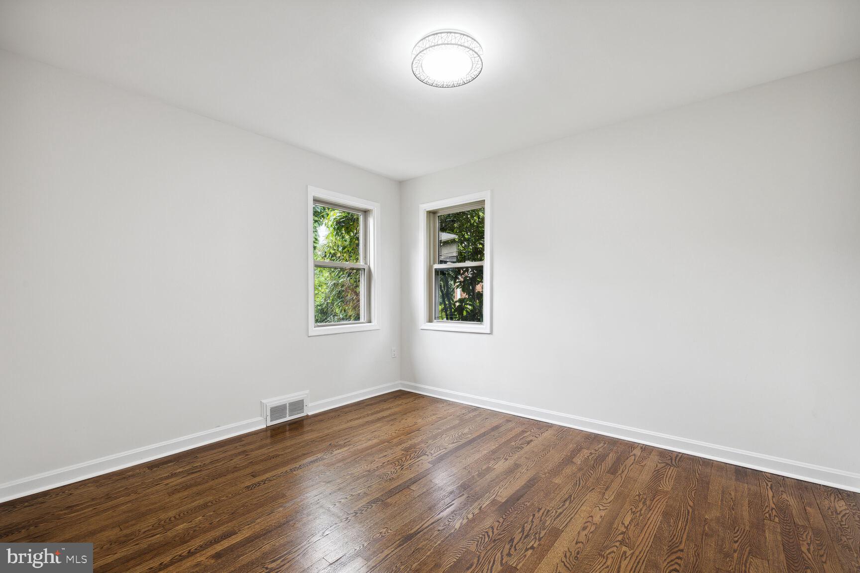 606 Biggs Avenue Frederick, MD 21702 - Photo 9 of 20 an empty room with wooden floor and windows